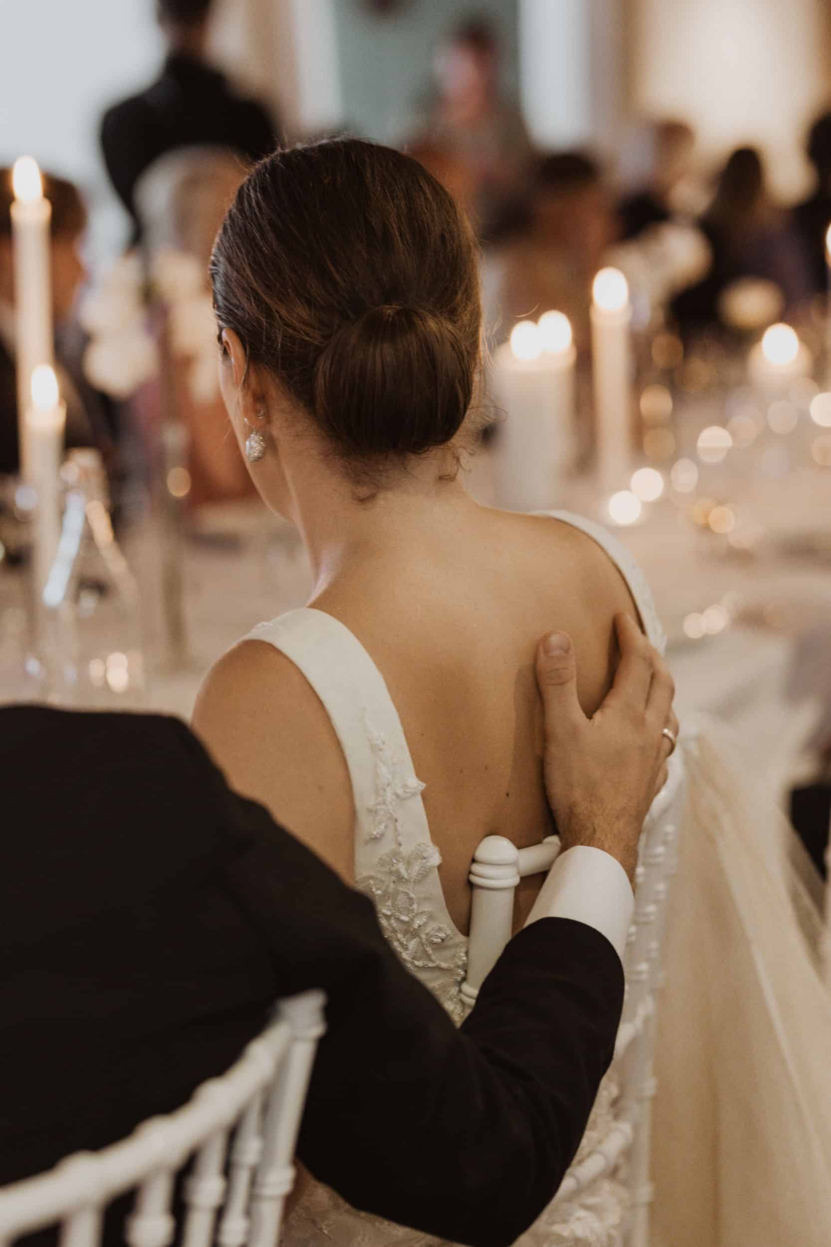 en rygg av en brud, og arm av brudgom på ryggen hennes