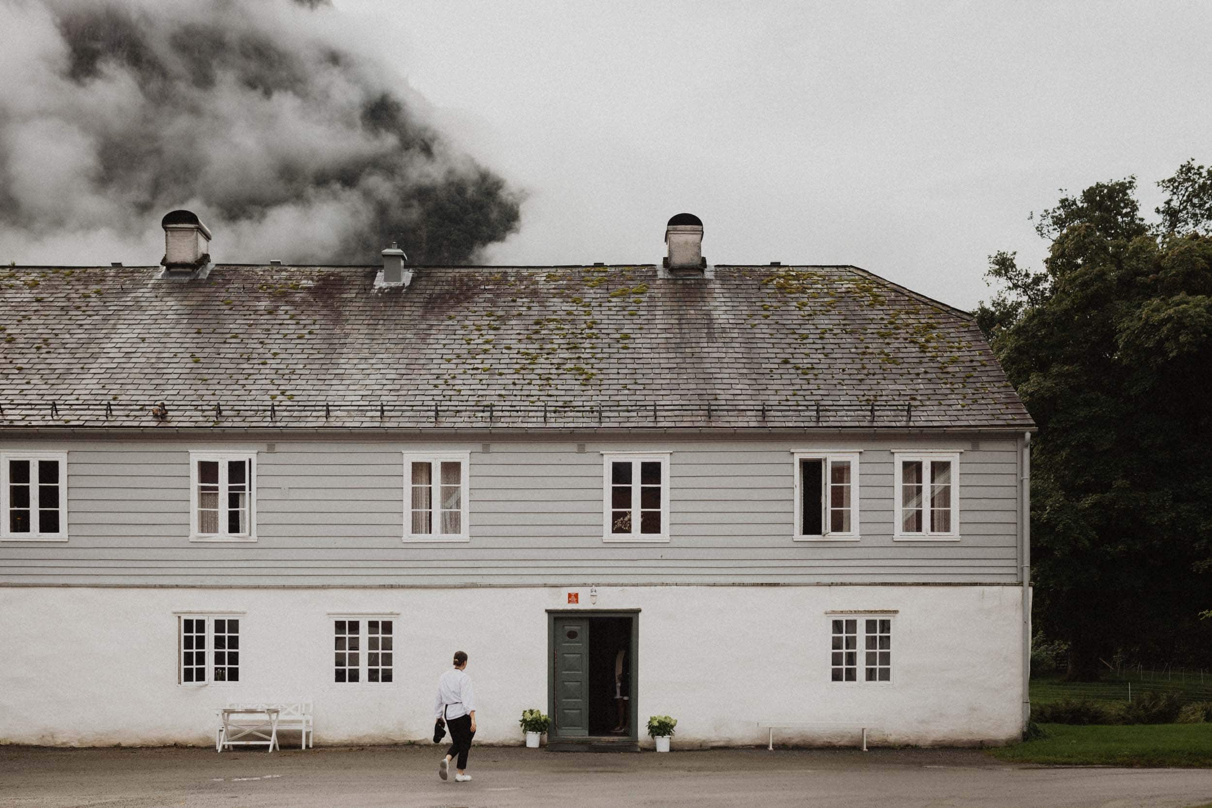 en hvit låve og et menneske som er på vei inn