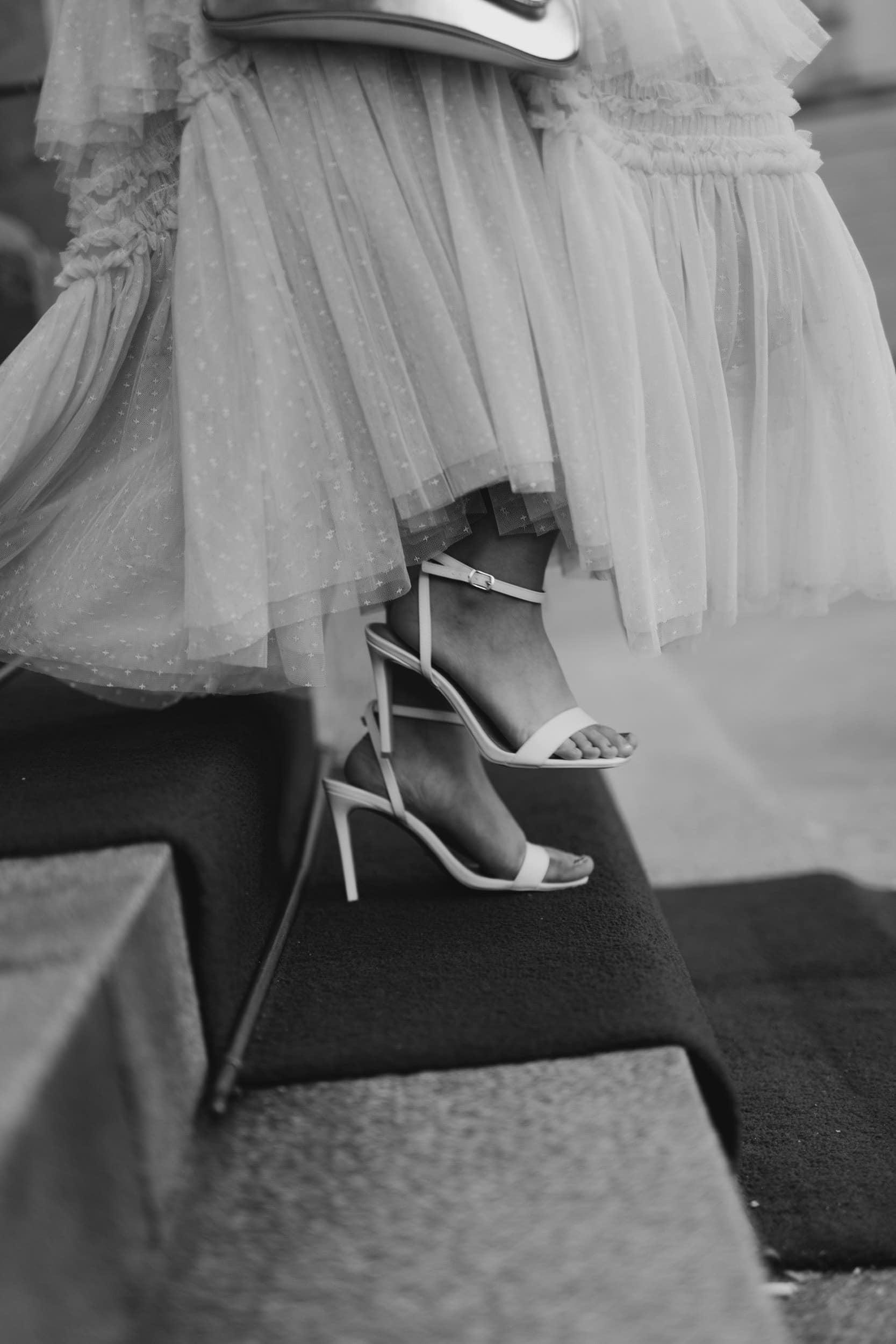 høye hæler og underdel av en hvit kjole på trapper
