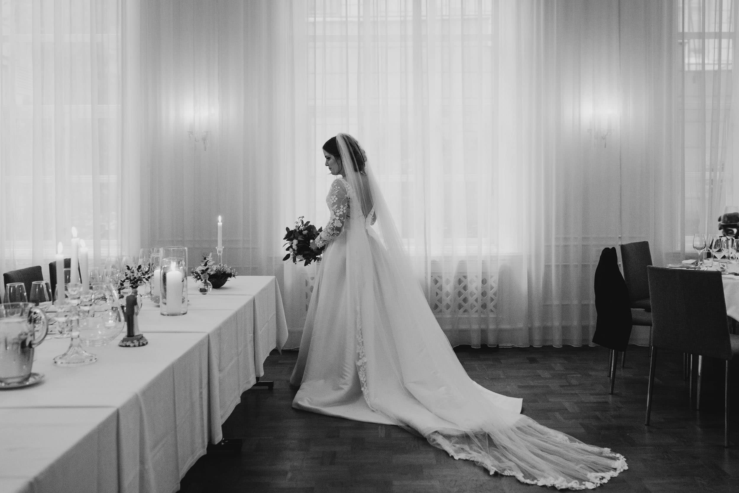 en brud i et rom med lang bord med hvit dukk