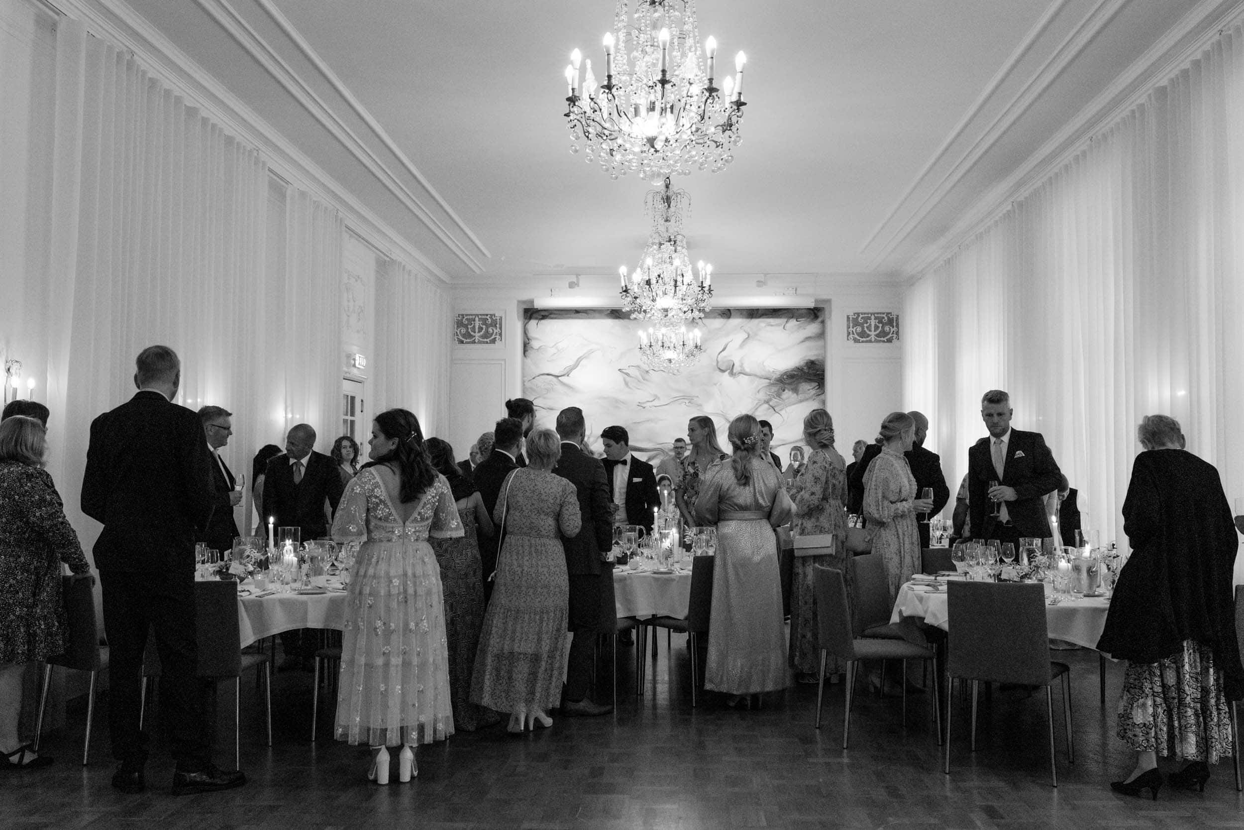 mennesker i fine klær som står i en elegant lokale