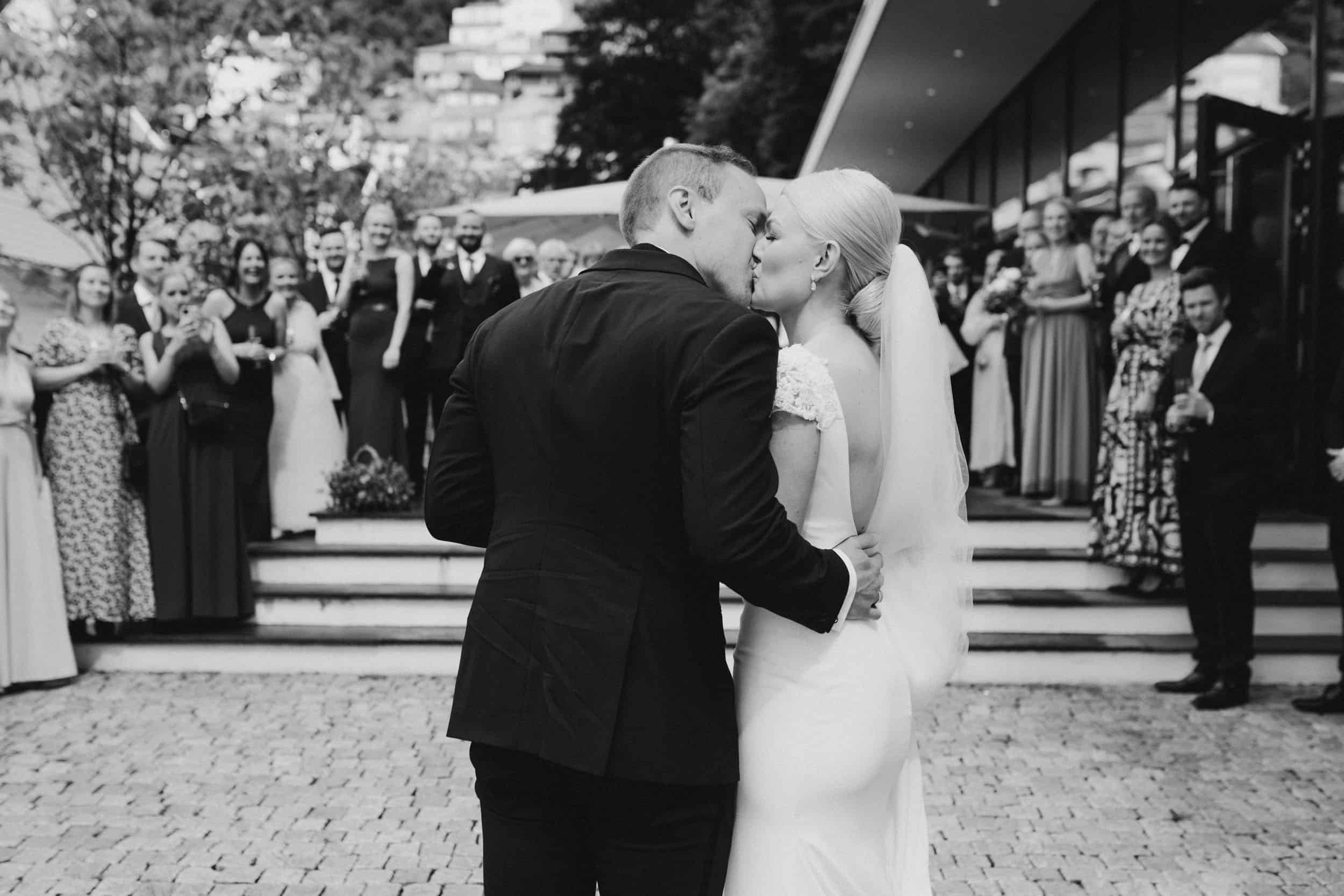 brudepar som kysser og mennesker rundt dem
