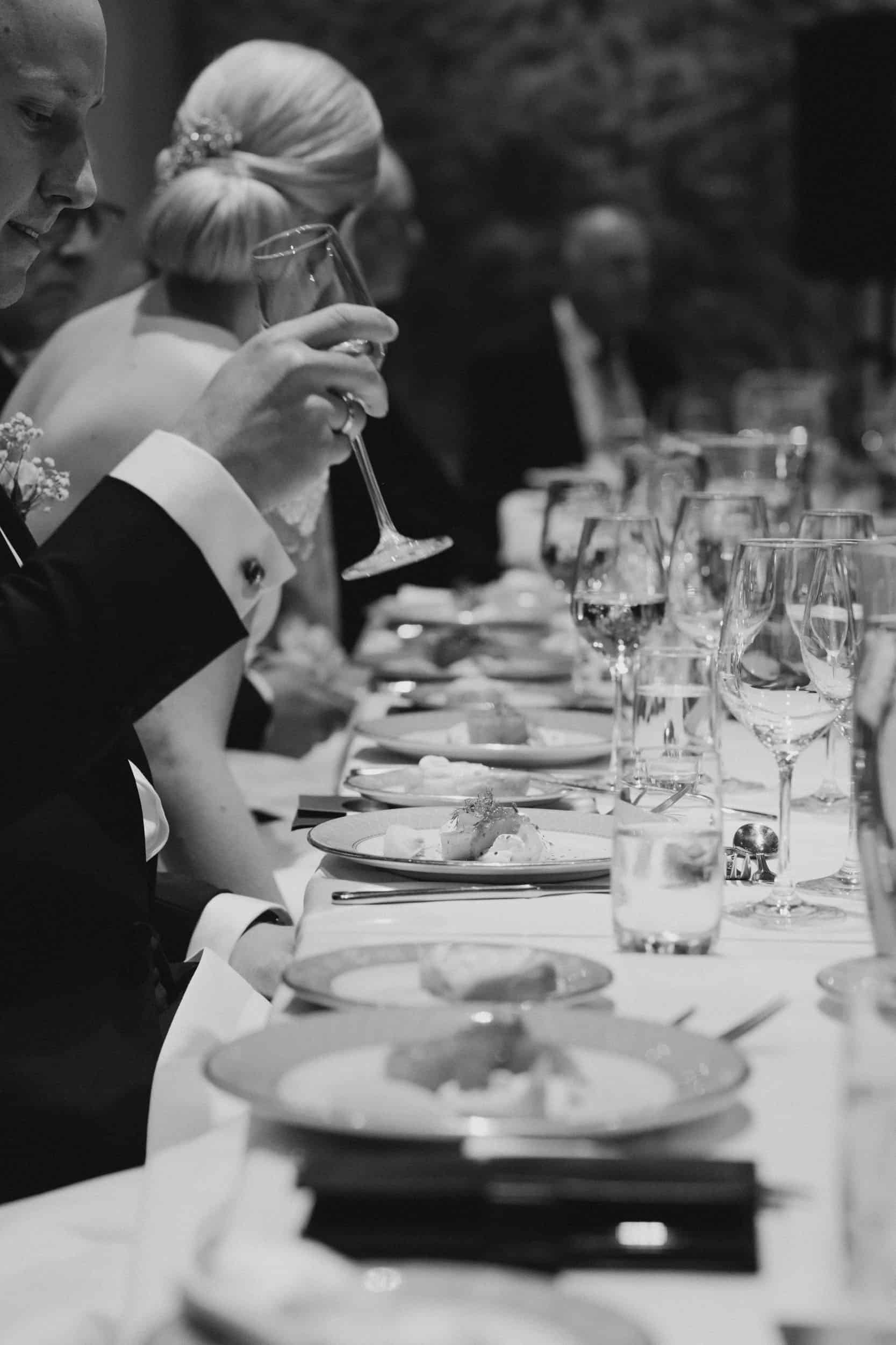 en mann som holder vinglass ved et bord med mat