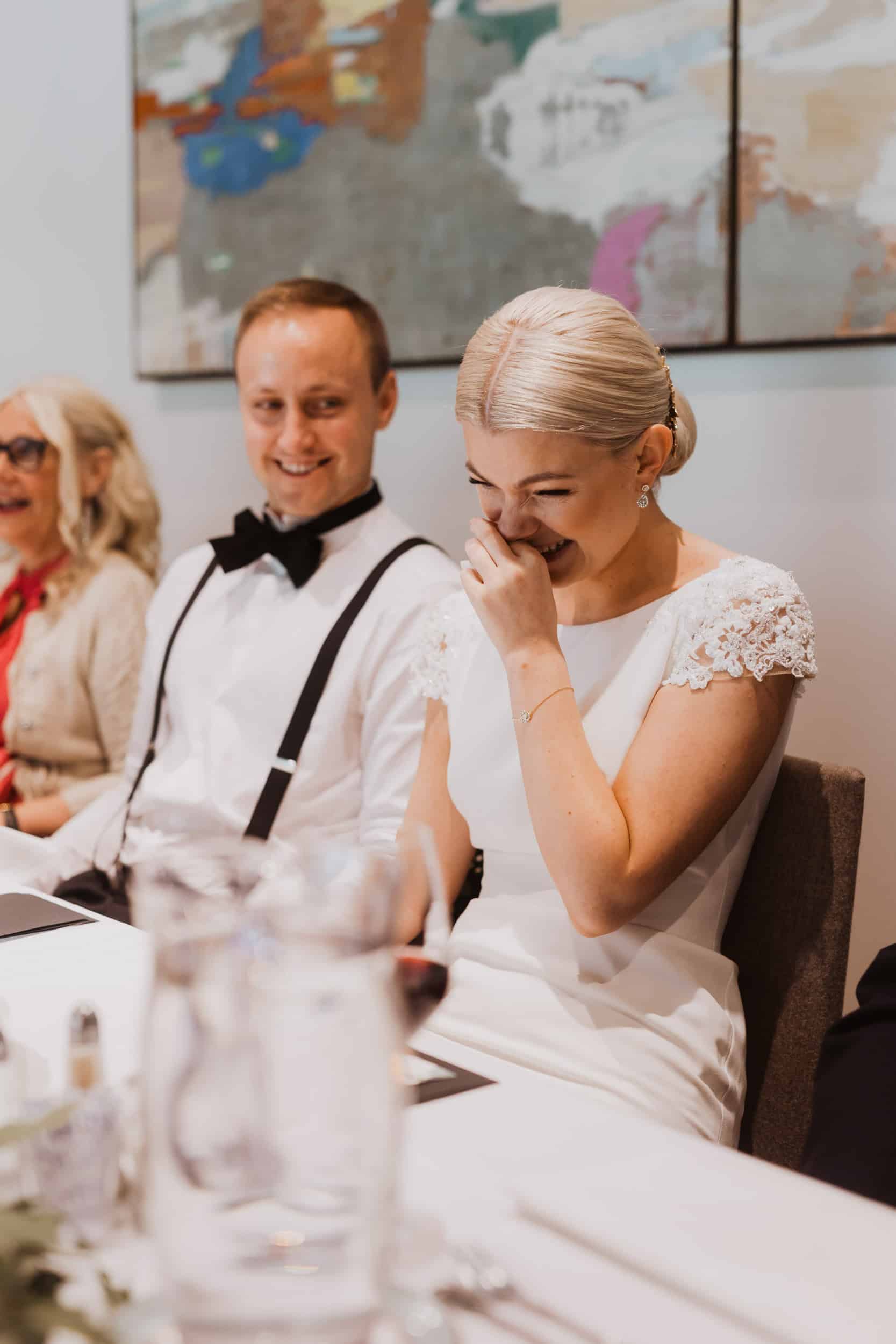 brudepar som ler med maleri bak dem