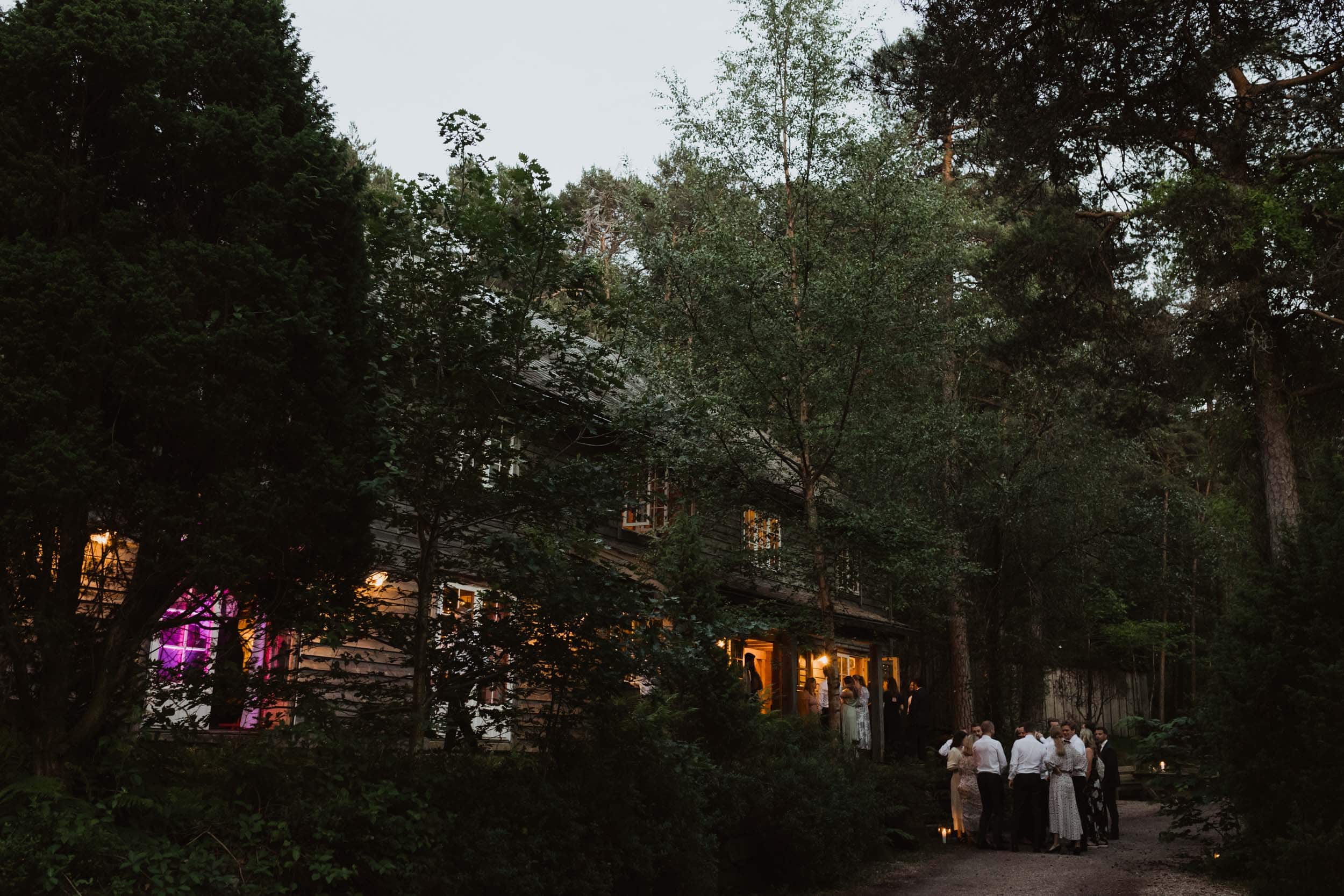 et hus i en skog og mennesker som står utenfor