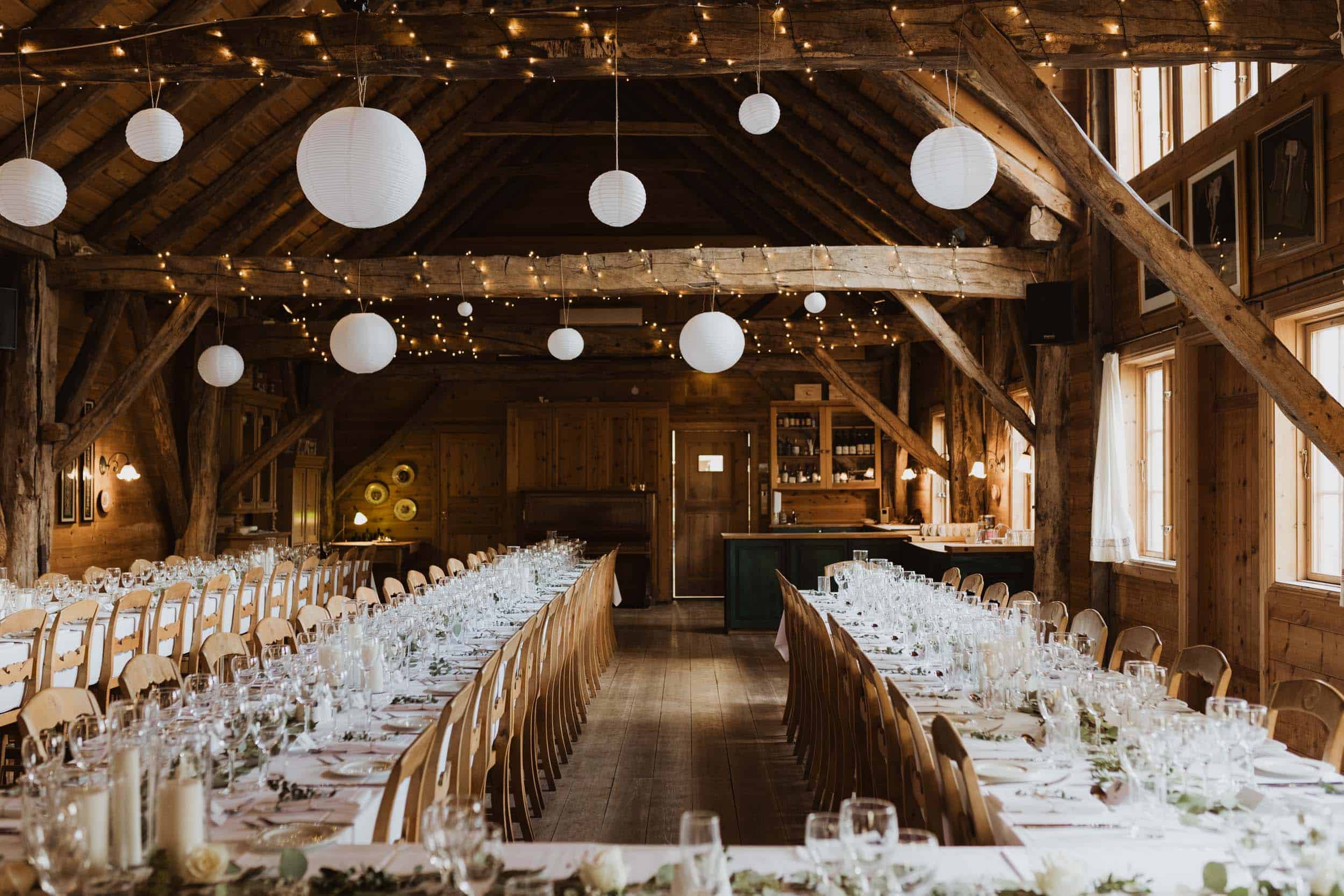 et spisesaal med trevegger, lange bord med hvite dukk og tre stoler