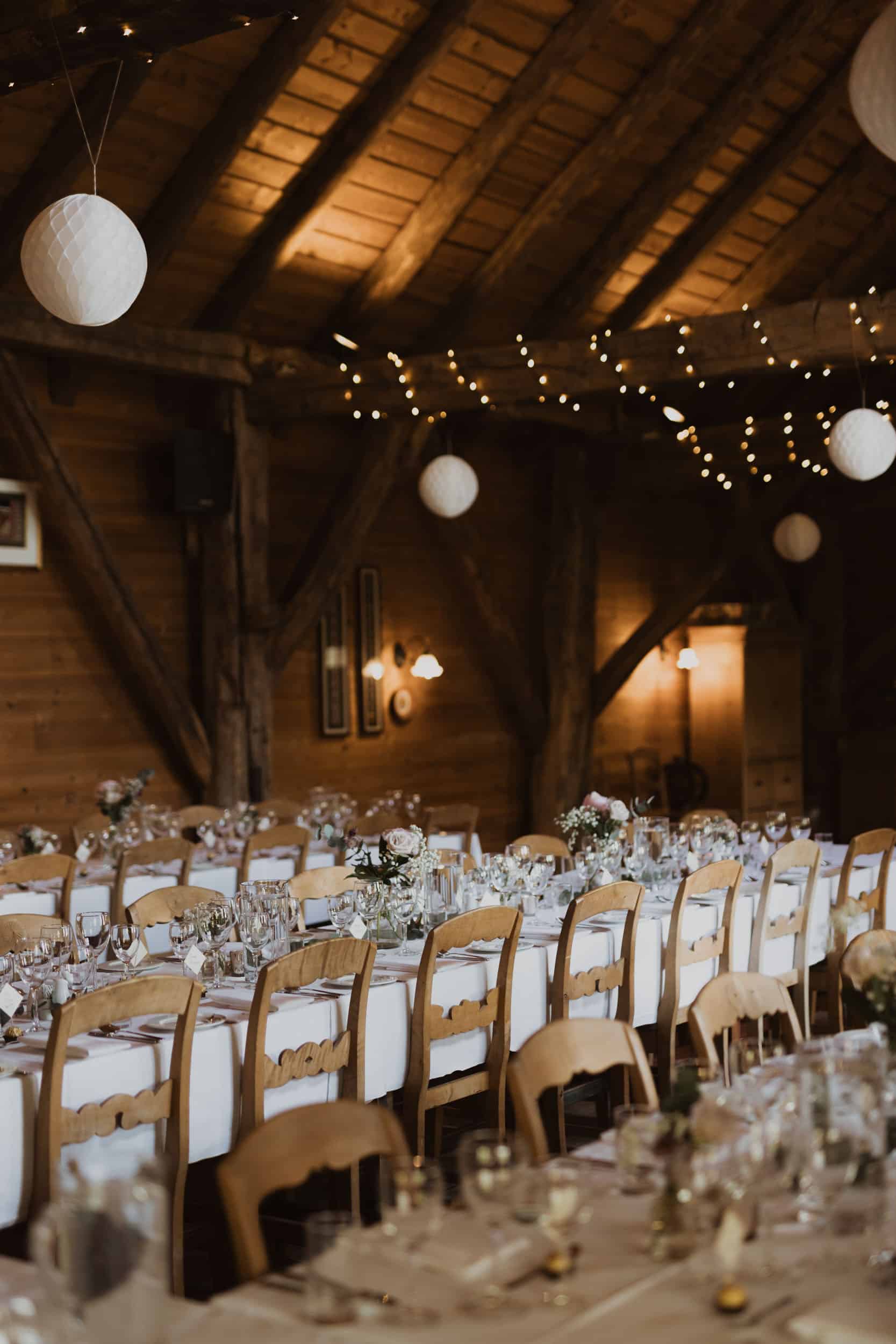 et spisesaal med trevegger, lange bord med hvite dukk og tre stoler