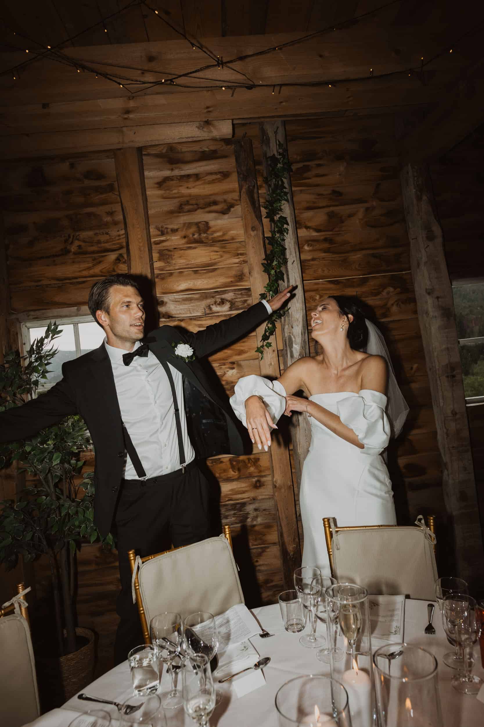 brudepar som jubler foran to stol mot tre vegg