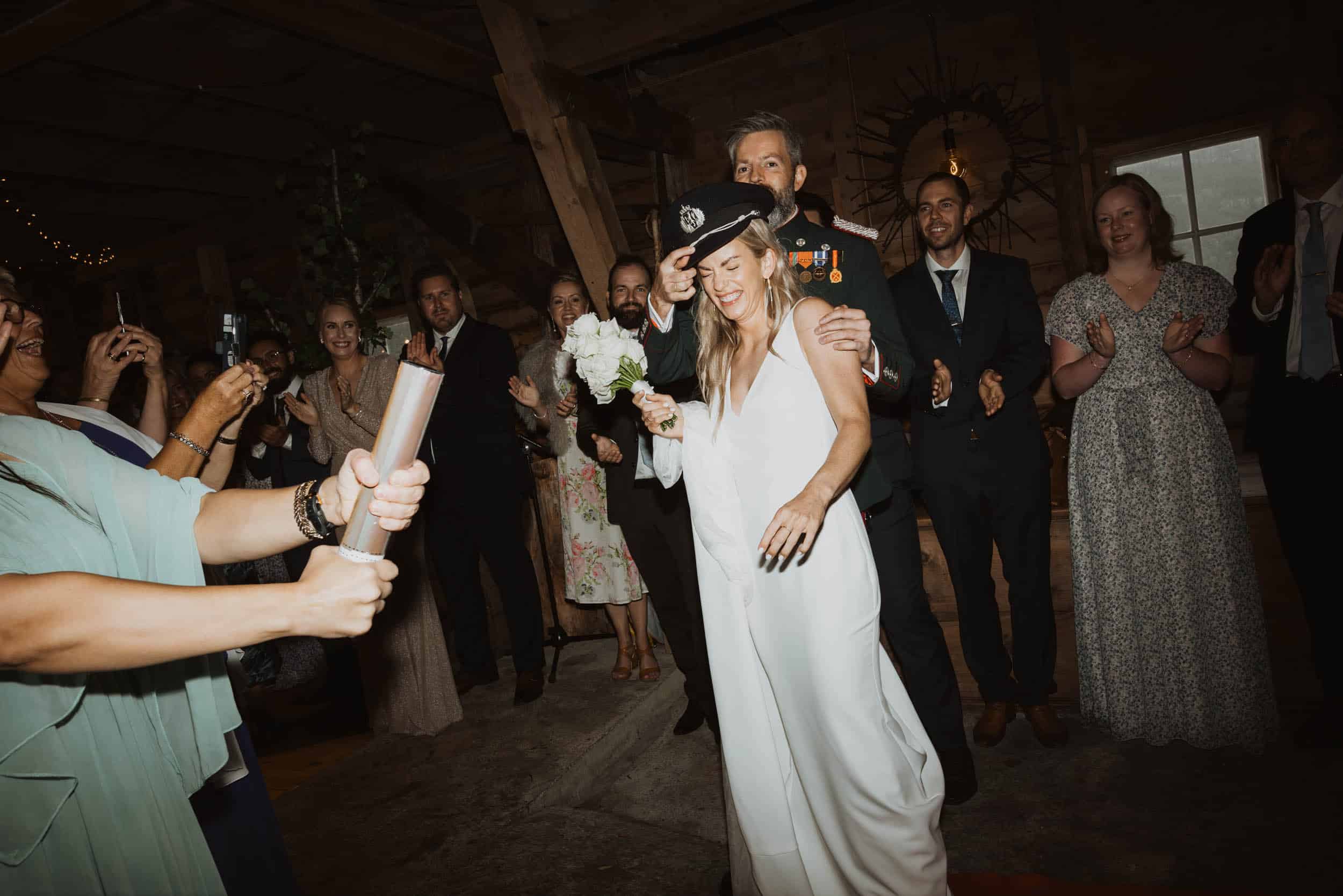 glade mennesker, en holder konfettikanon og bruden smiler