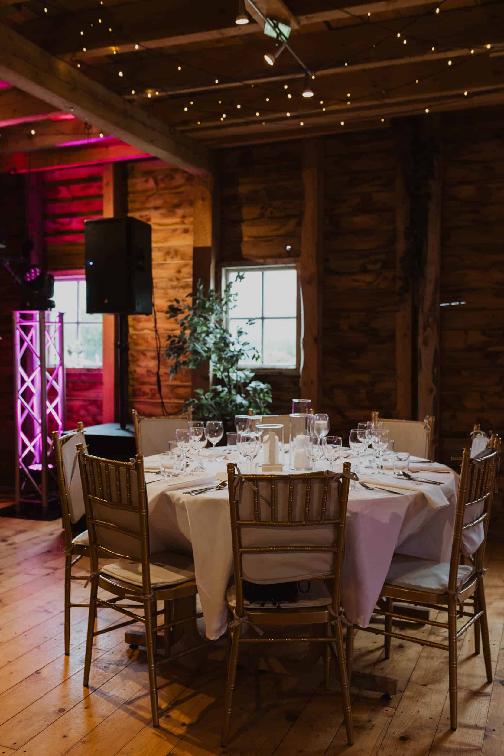 et pyntet lokale med tre vegg, runde bord med hvite dukk og gule stoler