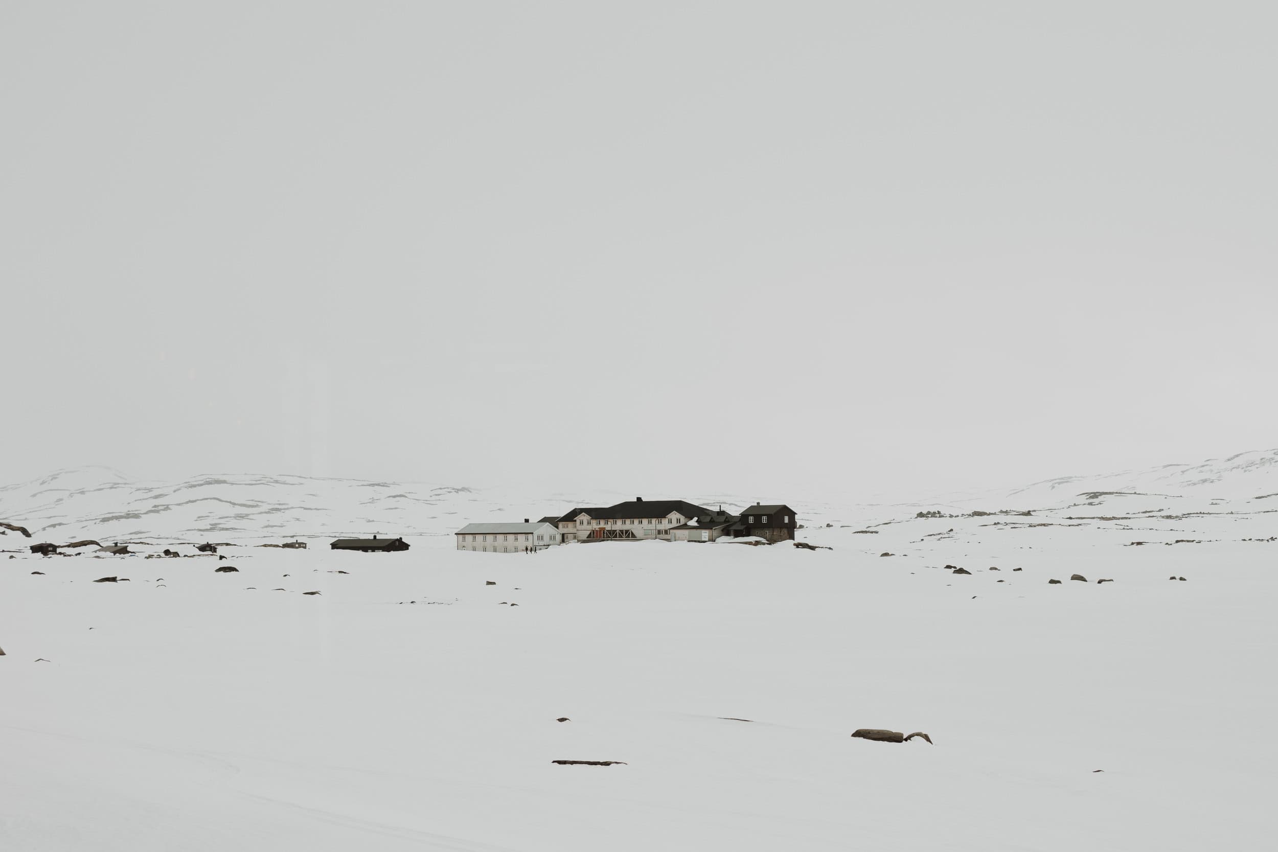 utsikt mot vinterlanskap med snø og et stort hus