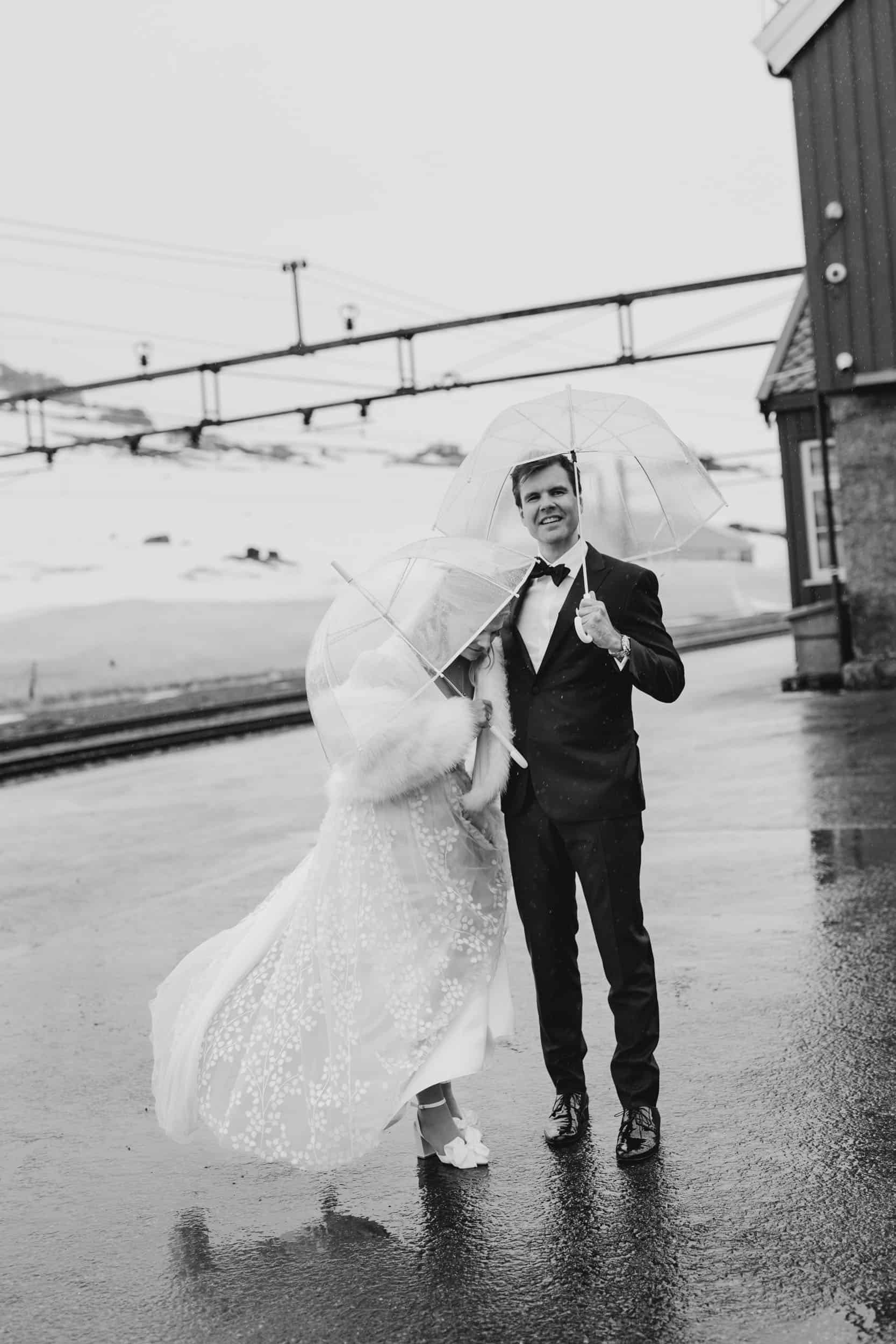 et brudepar står under paraply