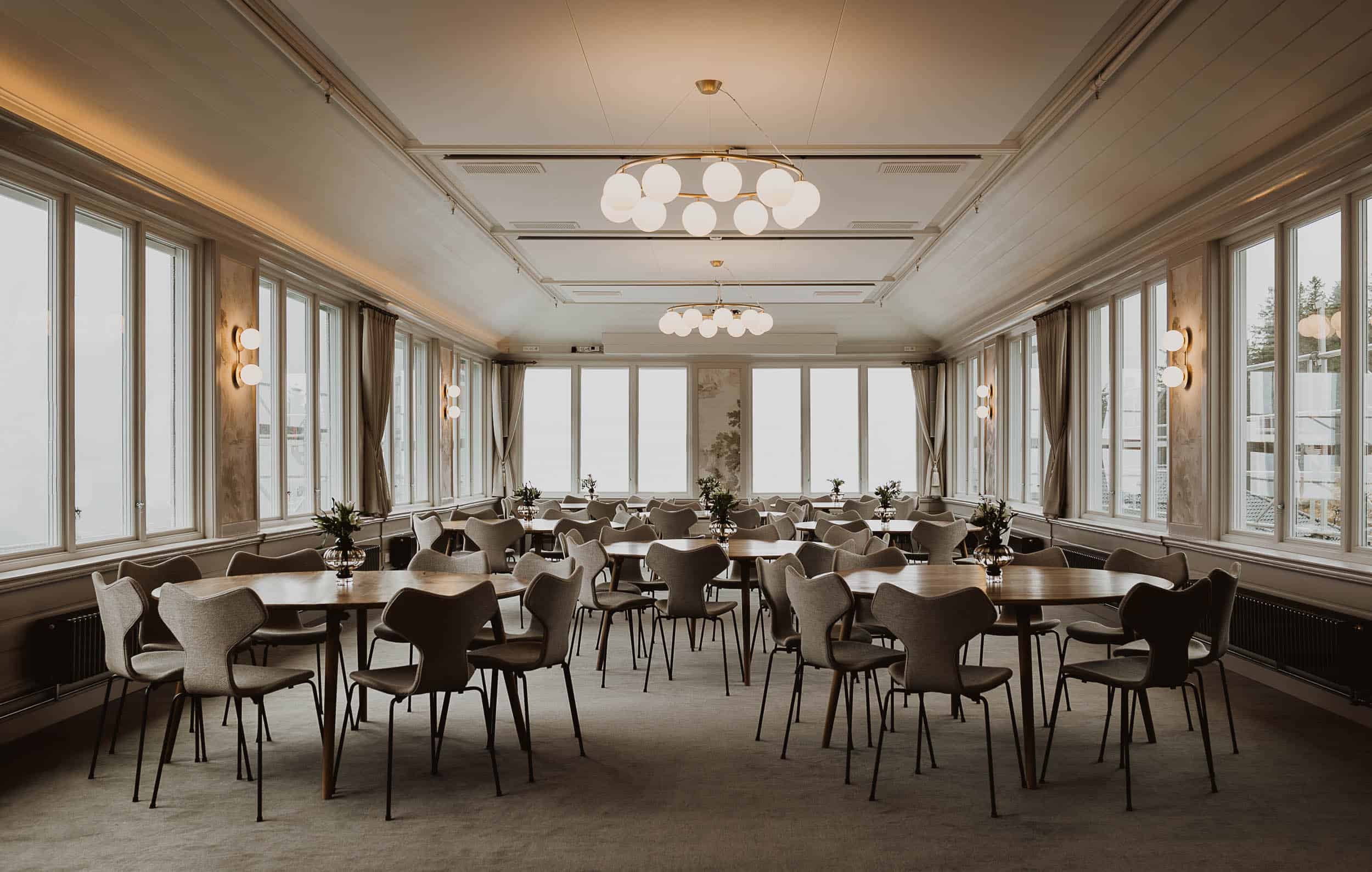 selskapslokale med stoler og bord og lamper og store viduer