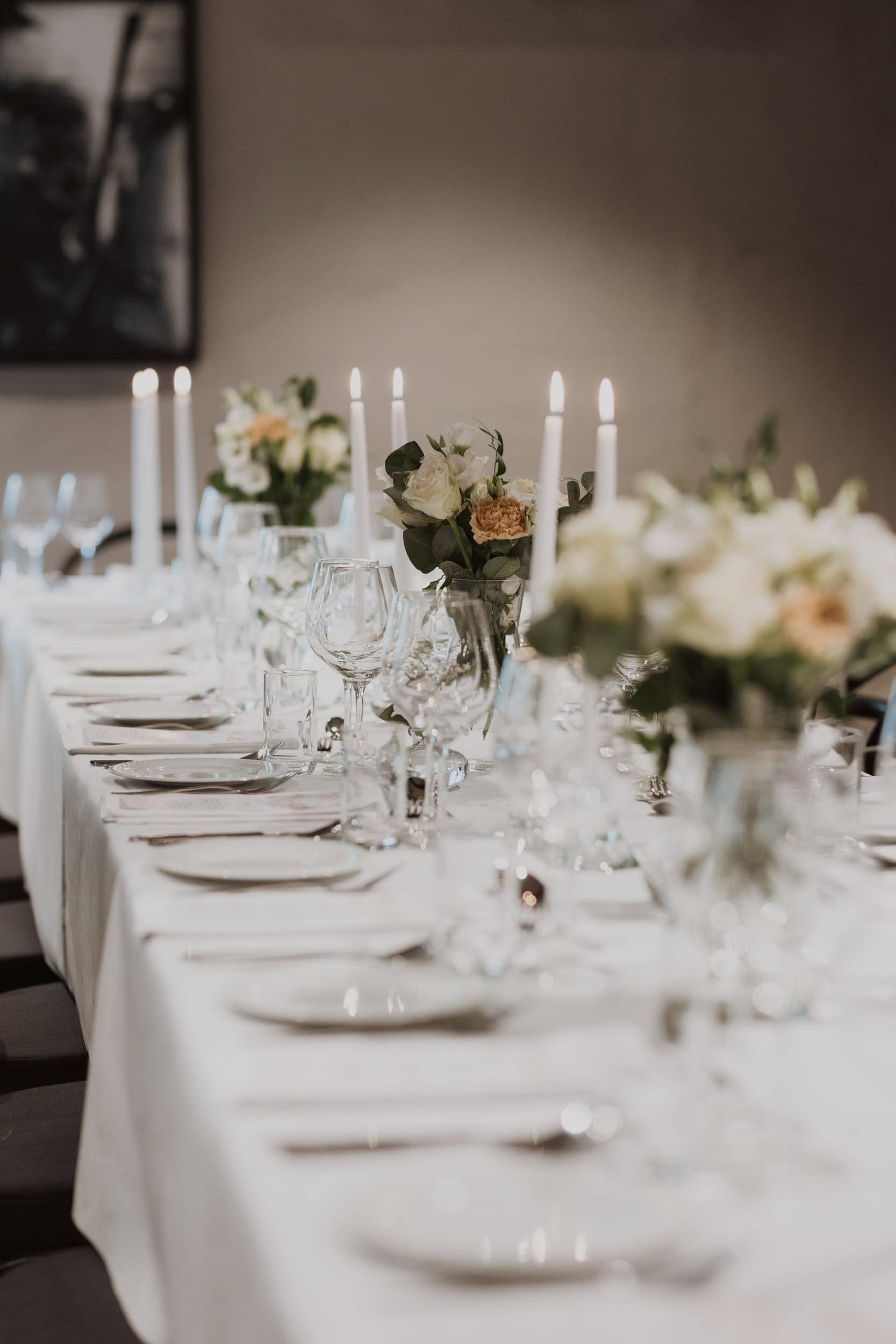 fint dekket bord men fat, bestikk, blomster og lys