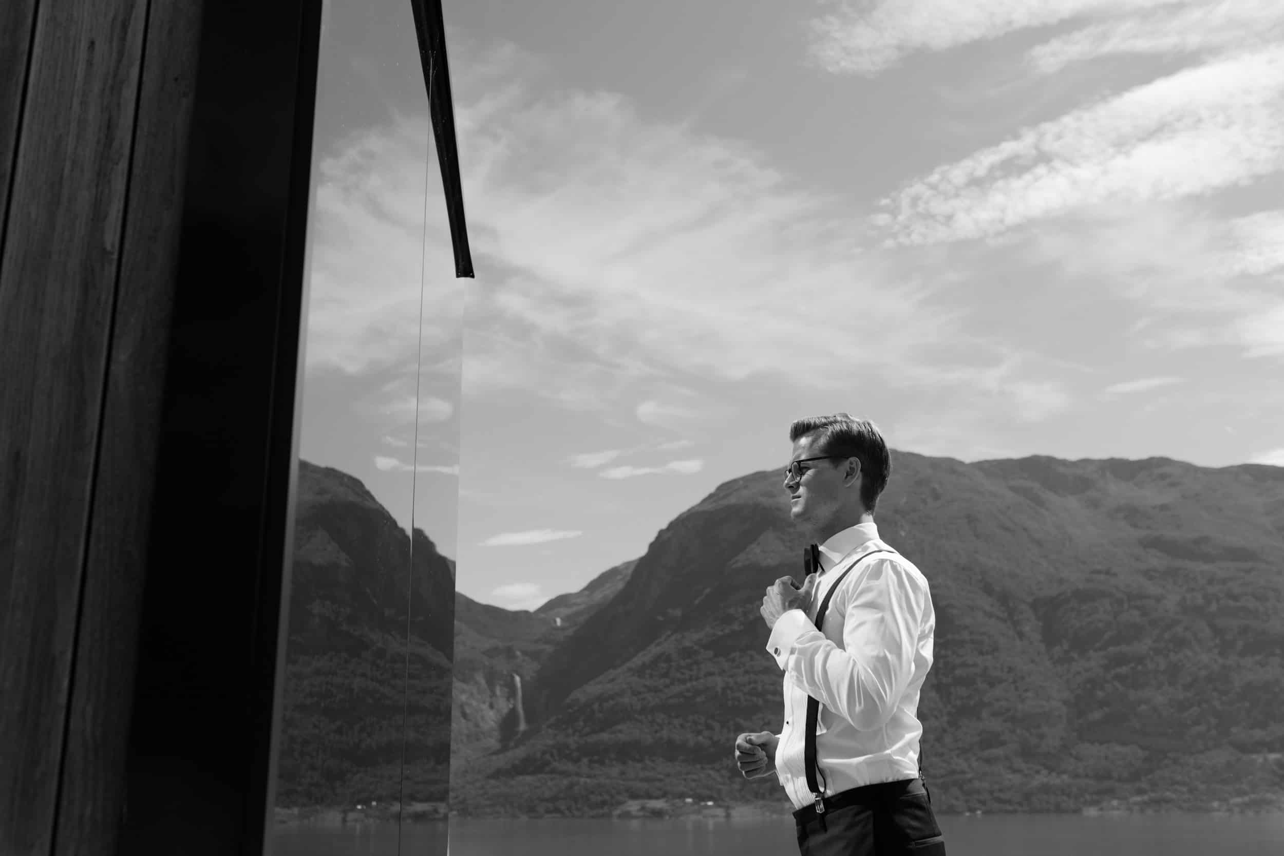 en mann i dress ser på refleksjon av seg selv i speilet